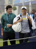 fokus. Caroline Wozniacki får følgeskab af kæresten Rory McIlroy efter en træningsseance på græsbanerne ved Eastbourne-turneringen. 