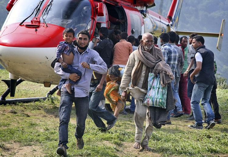 Indien. Pilgrimme, som har været fanget i bjergene i delstaten Uttrakhand, bliver fragtet væk med helikopter. 