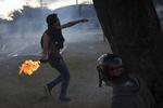 Uro. En demonstrant kaster en Molotov-cocktail mod politiet, nær Mineirao-stadionet inden aftenens kamp. 