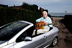 Glæder. Johnny Reimer glæder sig dagligt over at køre i lækre biler som denne Peugeot 307 cabriolet og over at eje en sjælden Høfner Commitee guitar, model 1957 i luksusversion med elfenben og tilmed signeret af idolet Tommy Steele. Foto: Jacob Ehrbahn 