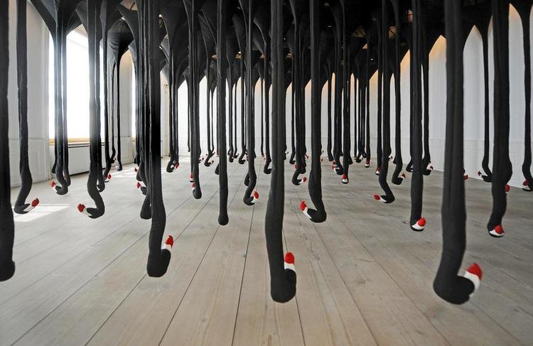 Totalinstallation. Alle værkerne på Henrik Vibskovs udstilling 'Neck Plus Ultra' udgør tilsammen en helhed. Ruminstallationen herover hedder 'Bird Kite Necks'. Til venstre vælter hvid uld ud af væggen i værket 'Face Wool Explosion'. Foto: Torben Stroyer/Gl Strand 