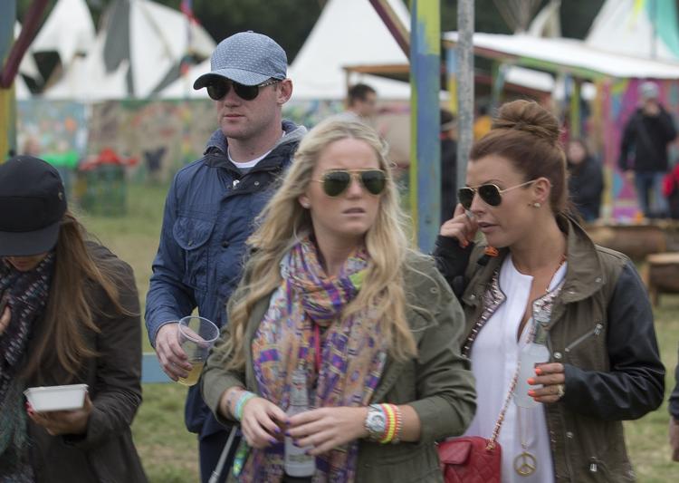 rock. Wayne Rooney (bagerst til venstre) bekymrer sig ikke synligt om virakken med hans eventuelle transfer. Lige nu er englænderen på rock-festivalen Glastonbury sammen med konen Coleen Rooney (th). 
