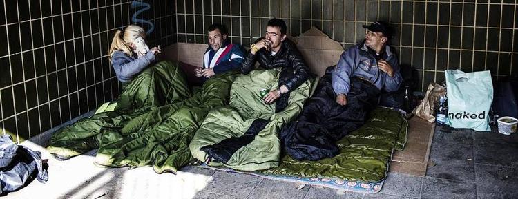 Fællesrum. Et stykke pap i bunden og to tæpper oven på, så er sengen klar. Alina gemmer sig bag bamsen ved siden af Nalu, Lucien og David. Alle er rumænere og søger arbejde i Danmark. 