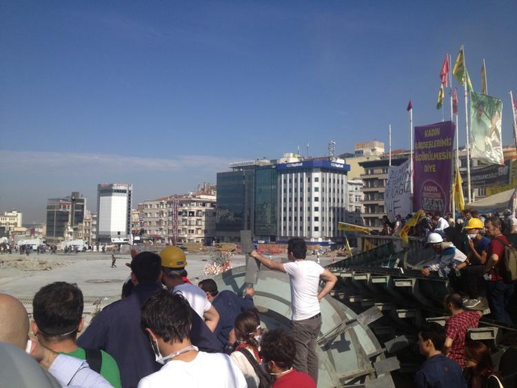 Afventer. Demonstranter holder øje med politiet på Taksim-pladsen i Istanbul. 