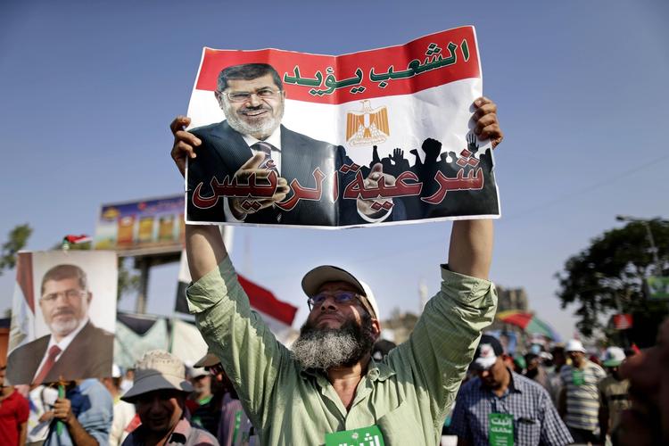 Vrede. »Folket støtter præsidenten«, står der på Morsi-tilhængerens banner. Det er ikke alle, der fester. 