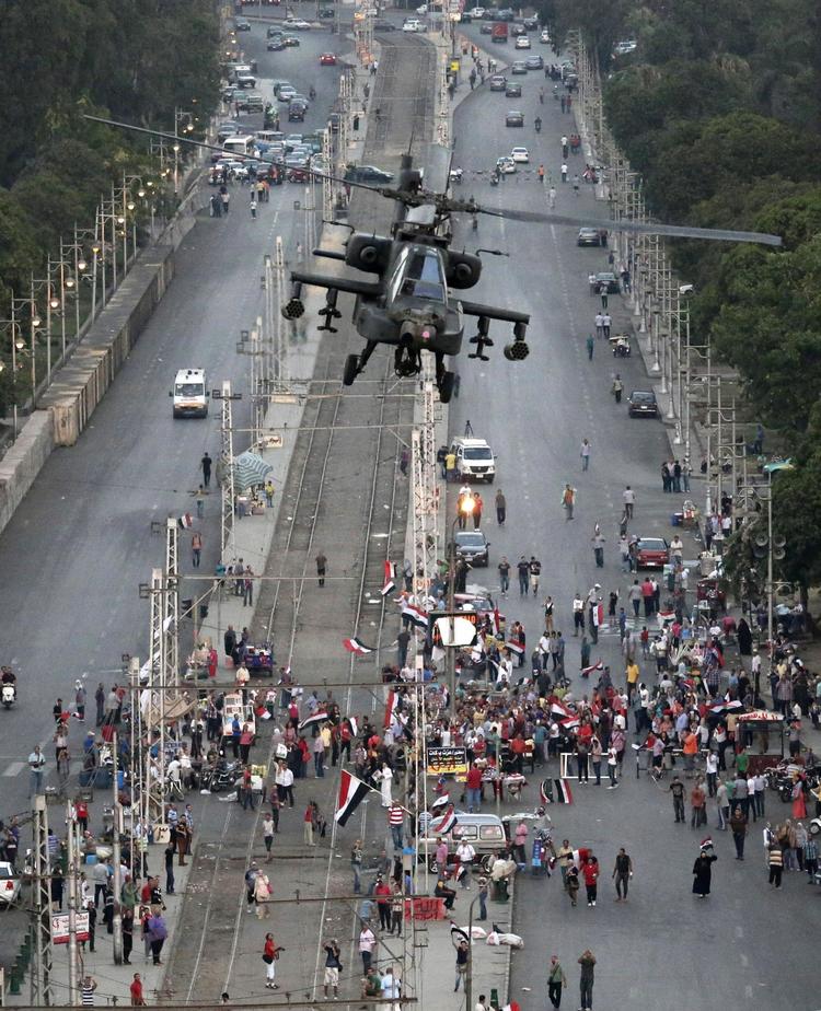Flag. Det egyptiske flag er overalt i Kairos gader i disse dage. Her flyver en militærhelikopter over en forsamling af Morsi-støtter, der holder til foran den militærbygning, hvor Morsi menes at blive holdt i husarrest. 