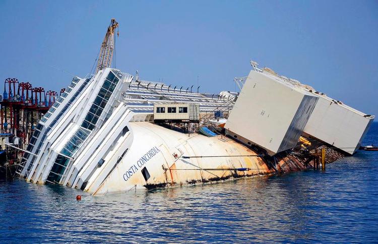 Bjærgning. Teknikere er netop nu i gang med at montere 30 meter høje metalkasser på 'Costa Concordia's skrog. 