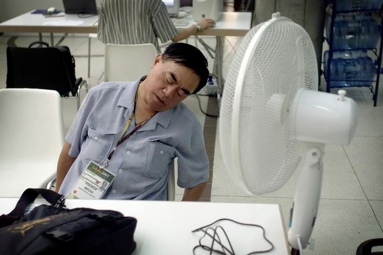 En reporter må give op da temperaturen når 35 graders varme ved et badminton VM i Sevilla. En ventilator køler kun lidt. ARKIV- 