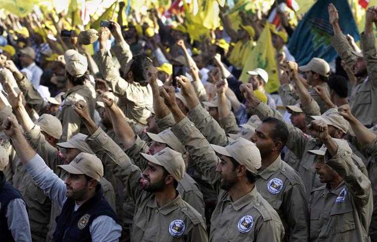 Militant. Medlemmer af Hizbollah marcherer, mens de råber slagord til bevægelsens leder, Hassan Nasrallah. 