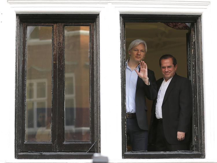 Eksil. Julian Assange (til venstre) kigger ud fra sit ophold på Ecuadors ambassade. Til højre står Ecuadors udenrigsminister Ricardo Patino. 