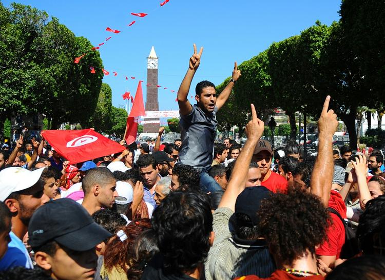 Opråb. Demonstranter samles i hovedstaden, Tunis, efter mordet på oppositionspolitikeren Mohamed Brahmi. Regeringspartiets lokaler blev angrebet i blandt andet Tunis. 