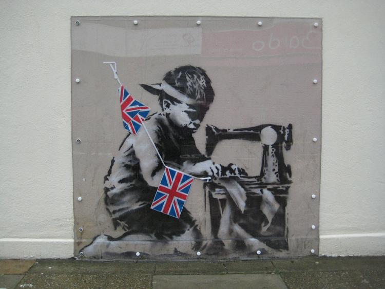 GRAFFITI. Banksy-værket fik navnet 'Slavearbejde (Flagguirlandedreng)', da det blev sat til salg i USA kort efter at være skåret ud af muren i en lavprisbutik i London. 