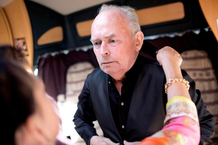 Showtime. June Belli hjælper sin ulv i tøjet og friserer ham, mens han samler sit fokus om, at han skal op og trykke den af. Hun har pakket skifte skjorter, så den svedende rockstjerne kan trække i en tør i pausen. 