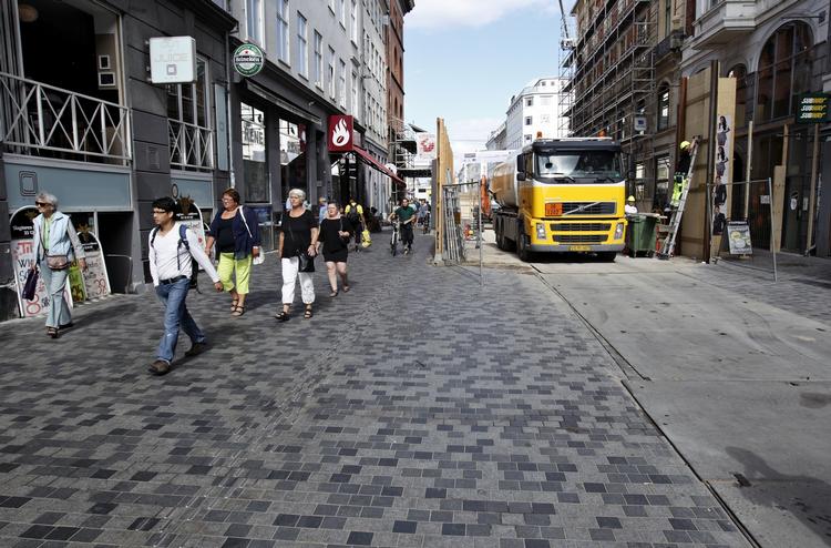 Skjult. Helt ude i højre hjørne af billedet - ved siden af den gule lastbil bag det høje finérhegn - ligger indgangen til tøjbutikken Invasion. 