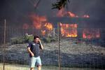STORBRAND. David Clarke fra byen Twin Pines taler i telefon ud for sit brændende hjem, en af de mange boliger, der er gået til under en omfattende naturbrand i det sydlige Californien. 