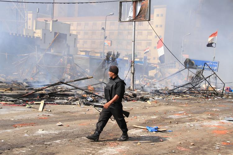 Voldsomt. En soldat fra de egyptiske regeringsstyrker går foran resterne af en af de lejre, som tilhængere af den afsatte præsident, Mohamed Morsi, har oprettet. 