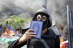 Rydning. Et medlem af af Egyptens sikkerhedsstyrker holder et eksemplar af koranen frem under den voldsomme rydning af demonstrantlejre i Kairo. 