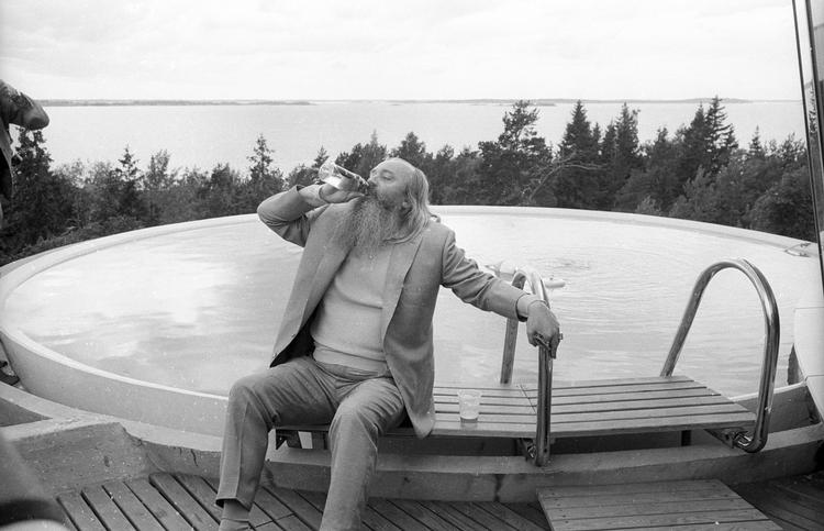 1969: Simon Spies underholder et mindre selskab i sit sommerhus Villa Spies - også kaldet Villa Fjolle - som ligger en snes kilometer syd for Stockholm med udsigt over skærgården. Huset er tegnet af den svenske arkitekt Staffan Berglund og stod færdigt i 1969. Det er cirkelformet og udstyret med datidens mest avancerede elektronik, hvorfor det i dag fremstår som et sjældent funktionalistisk/futuristisk arkitektonisk værk. 