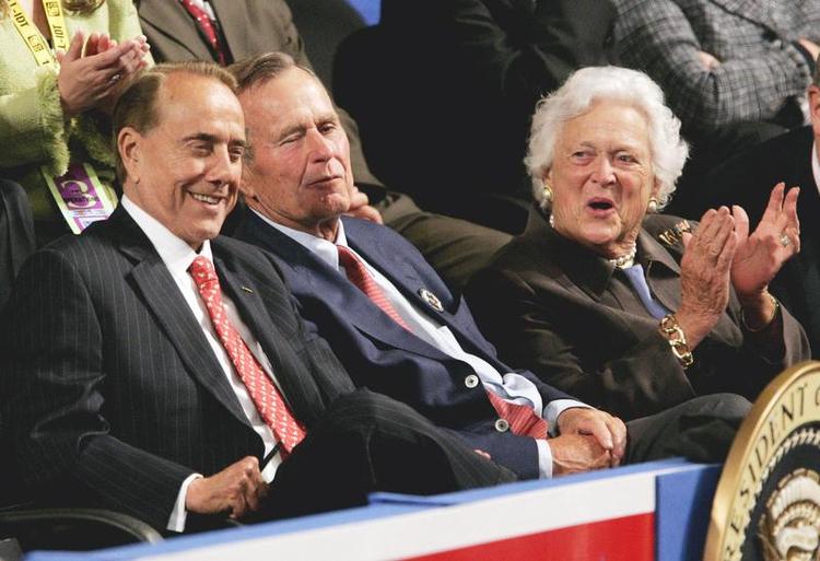 Kandidat. Bob Dole, der havde været guvernør i Kansas, sidder til venstre sammen med fhv. præsident George H.W. Bush og dennes Hustru Barbara, mens Doles hustru, senator Elizabeth Dole, taler på Republican National Convention i august 2004. 