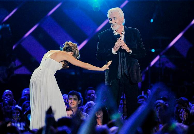 Respekteret. Sangerinden Sheryl Crow nejer for Kenny Rogers ved præsentationen af prisen for Årets Video video 2013 ved CMT Music Awards i Nashville, Tennessee, i juni. 