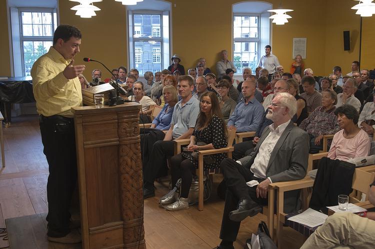 Holdningsskift. Ahmed Akari taler til sine gamle fjender i Trykkefrihedsselskabet. På forreste række en af foreningens frontfigurer, Lars Hedegaard, der selv har været udsat for et endnu uopklaret skudattentat. 