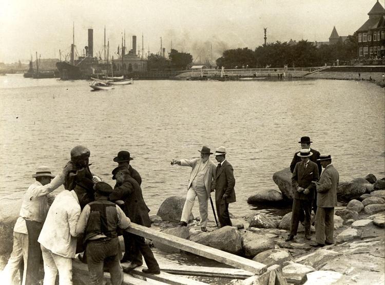 Fødselar. Her ses brygger Carl Jacobsen og skulptør Edvard Eriksen 23. august 1913 under placeringen af Den Lille Havfrue ved Langelinie Kaj. 100-årsdagen fejres fredag sammesteds - og på Carlsberg. 