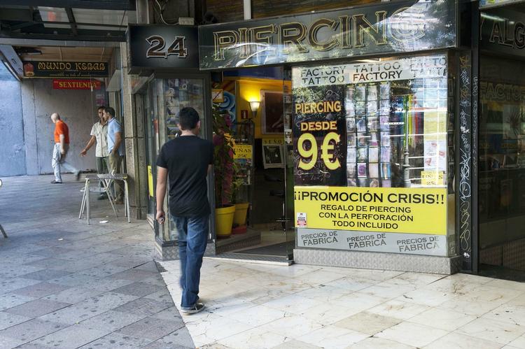 krisetilbud. Spanien er et af de lande, der er hårdt ramt af finanskrisen. Forretningerne prøver med alle midler at holde på kunderne. Denne lokker med et specielt 'finanskrise-tilbud': Piercingerne for ni euro. 