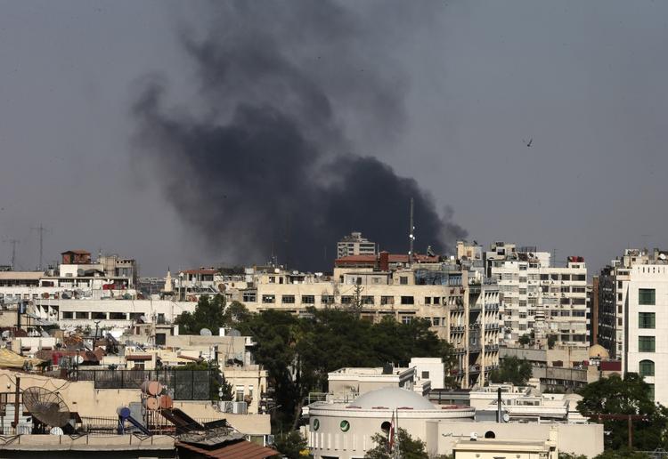 OPRØR. Mens omverdenen diskuterer, hvordan der skal reageres på mistanken om kemiske angreb ved Damaskus, så fortsætter kampene mellem oprørere og regeringshær i Syrien. Her ses en røgfane stige til vejrs efter bombardementer af Jobar-distriktet øst for hovedstaden. 