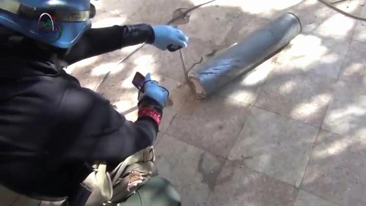 inspektion. Billedet er taget fra en amatørvideo og forestiller angiveligt en formodet våbeninspektør fra FN, der er ved at undersøge en cylinder i området uden for Damaskus i Syrien, hvor hundredvis døde af et formodet kemisk angreb. Spørgsmålet er, om USA vil vente på inspektørernes konklusion. 