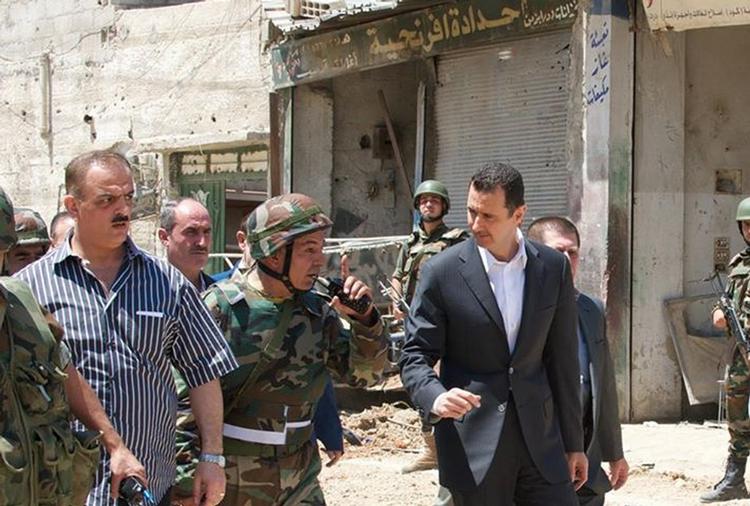 syrien. Har det internationale samfund grundigt afprøvet og udtømt alle diplomatiske muligheder i Syrien? Nej, skriver Søren Friis, der også mener, at det er tvivlsomt, at man har sikret sig, at en militær intervention ikke vil ramme den syriske civilbefolkning. Her billede udsendt af det syriske styre 1. august af præsident Assad (th) i byen Daraya syd for Damaskus. 