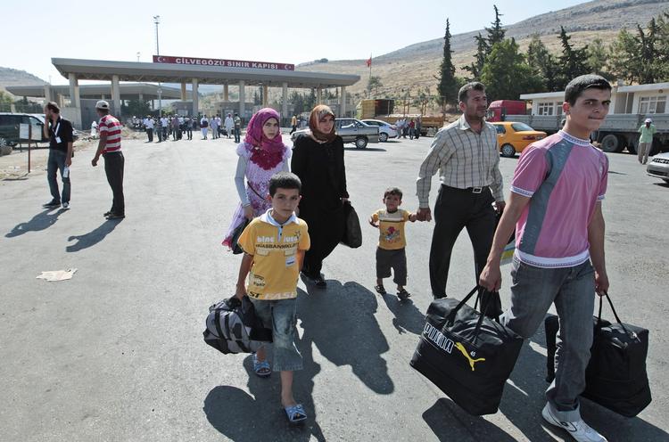 Flugt. Hvis politikerne vælger at gå militært ind i Syrien, vil det øge strømmen af flygtninge, mener nødhjælpsorganisationer. Personerne på billedet flygtede i går fra Syrien ind i Tyrkiet. - Foto: 