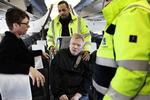 Assistance. To Falck-ansatte hjælper Stig Langvad til rette i flysædet. Han er handicappet og kan ikke klare sig selv på en flytur. 