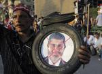 OPGØR. Oppositionsstøtte med et foto af den afsatte præsident Mohamed Morsi. Striden om hans varetagelse af landets ledelse har givet voldsomme sammenstød i Egypten, hvor et stort antal Morsi-støtter nu har fået fængselsstraffe. 