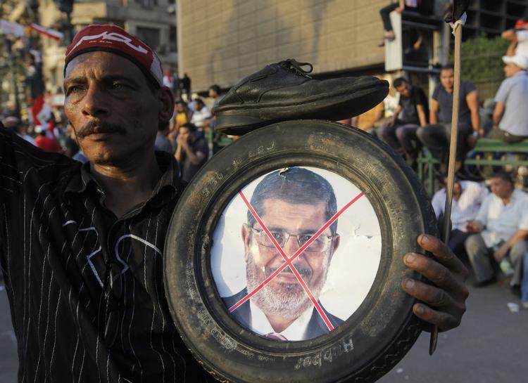 OPGØR. Oppositionsstøtte med et foto af den afsatte præsident Mohamed Morsi. Striden om hans varetagelse af landets ledelse har givet voldsomme sammenstød i Egypten, hvor et stort antal Morsi-støtter nu har fået fængselsstraffe. 