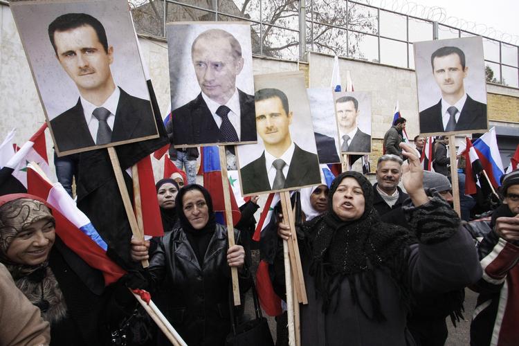 Opbakning. Civile demonstrerer i Damaskus gader til fordel for Bashar al-Assad. Der er - som man kan se - også støtte til Putin. 