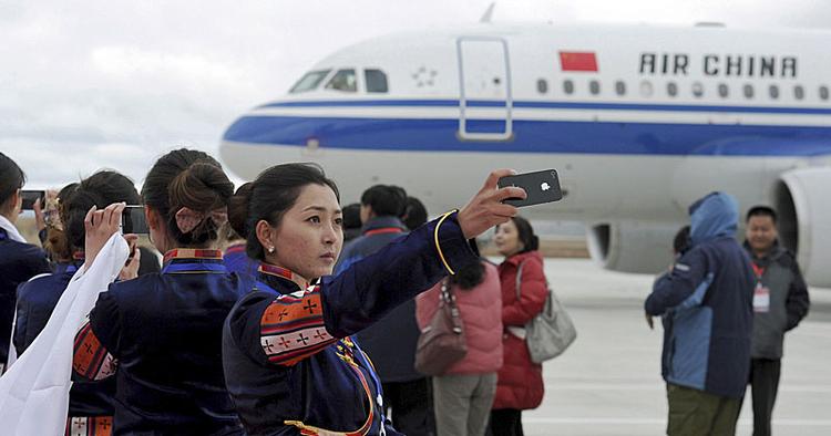 Premiere. En tibetansk kvinde tager et selvportræt i forbindelse med en landing i Yading-lufthavnen. 