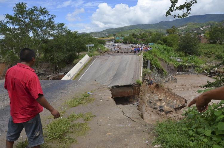 Stormskader. En mand betragter en kollapset bro over Huacapa-floden i Mexico, der er plaget af regn og oversvømmelser. 