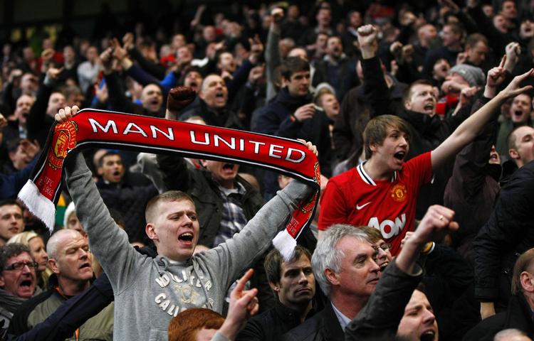 støjforøgelse. Medlevende Manchester United-fans under en kamp mod Manchester City i 2012 på udebane. Kampene på hjemmebanen Old Trafford er ofte betegnet ved tavshed på lægterne. 