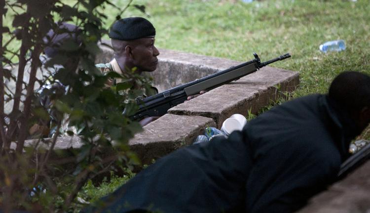 Gidseldrama. Kenyanske sikkerhedsstyrker søger dækning tidligt i morges kort efter, at der lød skudsavler inde i det besatte Westgate-shoppingcenter i Nairobi. 