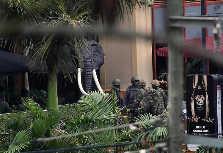 Terror: Kenyanske sikkerhedstyrker samlede sig tirsdag ved indgangen til det terrorramte Westgate indkøbscenter i Nairobi. 