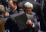 Vedtaget. USA's udenrigsminister, John Kerry, og Rwandas FN-ambassadør Eugene-Richard Gasana omfavner hinanden efter afstemningen om Syrien. 