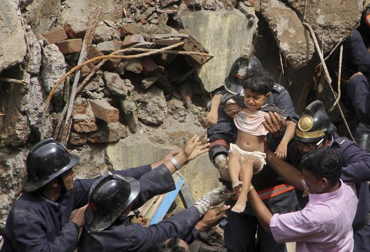 Tragedie: Dødstallet siger i indiske Mumbai hvor en stor etagebyning fredag styrtede sammen. Fredag lykkedes det at redde en lille pige ud af ruinerne. 
