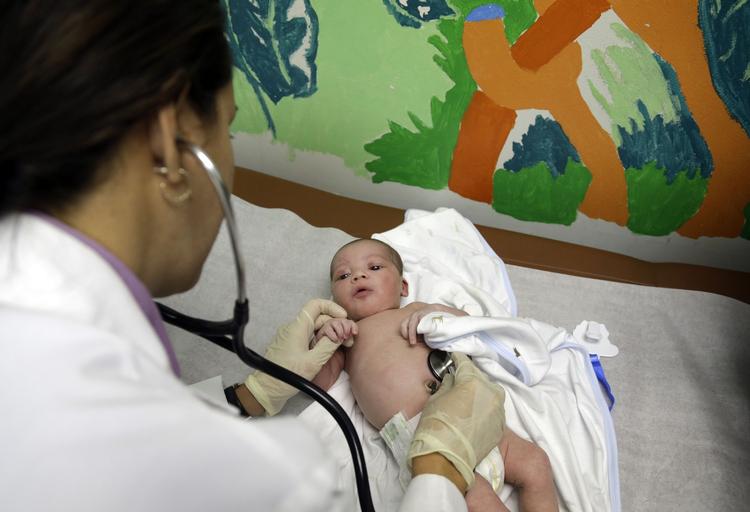 Uforsikret: Dr. Kenia Martines undersøgte i sidste uge den nyfødte baby Kaden Thomas McGee på en klinik i Cutler Bay i Florida. Moderen  havde ikke en sundhedsforsikring på det tidpunkt, men det åbner Obamas sundhedsreform nu op for at hun kan få. 