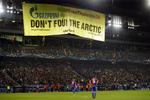Protest. Et kæmpe banner foldede sig pludselig ud fra stadiontaget, hvorfra aktivisterne hang i stålwirer. 