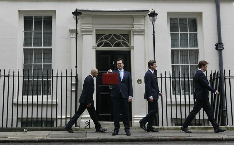 optur. Nej, det er ikke direktør Hallandsen fra Olsen Banden-filmene med alle millionerne, men den britiske finansminister, George Osborne, som flasher sin berømte britiske til embedet hørende røde kuffert foran Downing Street nr. 11. 
