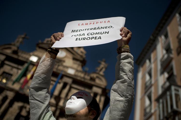 Protest. En italiensk demonstrant holder et banner med teksten: »Lampedusa, Middelhavet, fællesgrav« under en demonstration i Pamplona i dag mod EU's indvandrepolitik. 