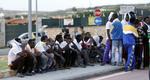 Forlis. Migranter fra Eritrea venter uden for en lufthavnshangar med kisterne med de skibbrudne på øen Lampedusa, Italien. 