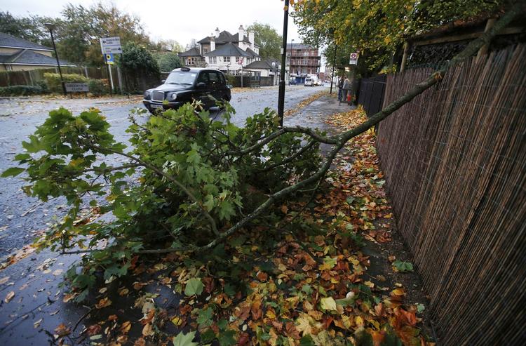 Orkanstyrke. I England har stormen siden i går raseret dele af landet med strømsvigt, oversvømmelser og faldne træer til følge. På billedet blokerer et væltet træ fortovet i London. 