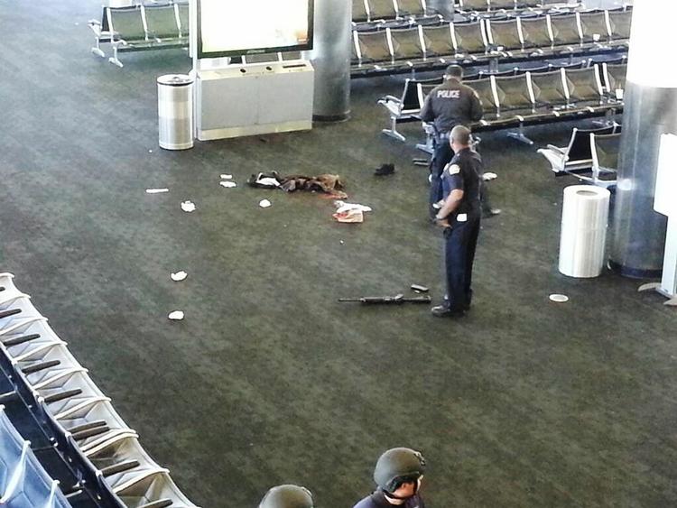 SKYDERI. Betjente ved et efterladt våben i Los Angeles internationale lufthavn efter drabet på en TSA-ansat. 