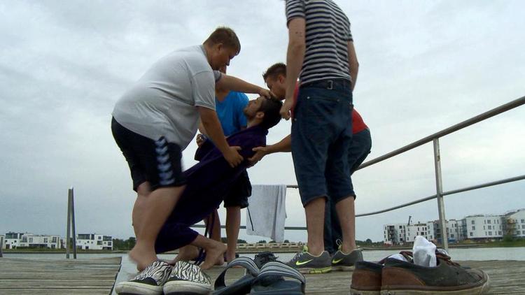 Nedlagt. Efter dåben i havets kolde vand overvældes den nyomvendte Samir af helligånden og ender strakt ud på badebroen. 